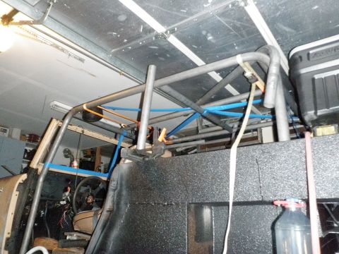 1961 International Scout 800 - A custom roll cage is being installed inside a vehicle, with parts of the interior visible.