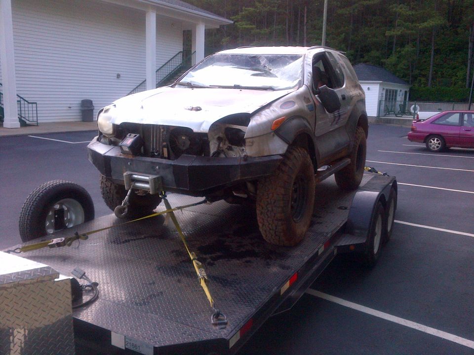Silver 1999 Isuzu Vehicross on trailer, front bumper removed, winch attached