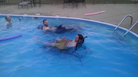 2000 Mercury Grand Marquis - Several men are enjoying a swim in a backyard pool on a warm day.