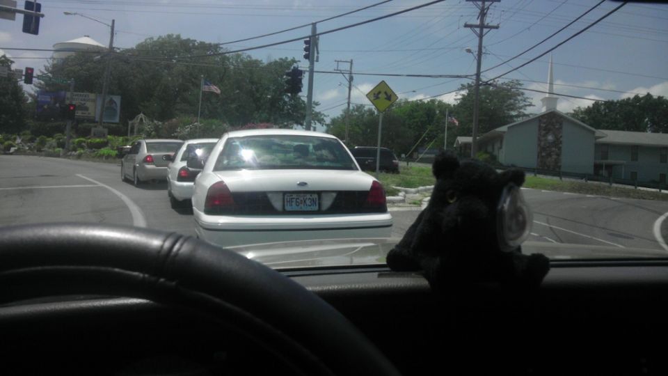 Three white sedans in traffic, front one has license plate F5X3N