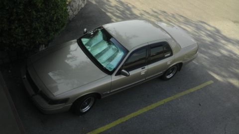 2000 Mercury Grand Marquis - A tan 2000 Mercury Grand Marquis sedan is parked in a lot, viewed from an elevated angle.
