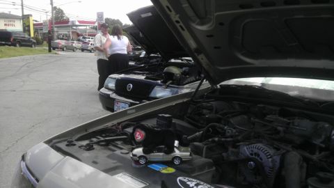 2000 Mercury Grand Marquis - Two 2000 Mercury Grand Marquis sedans are displayed with their hoods open, revealing their engines.