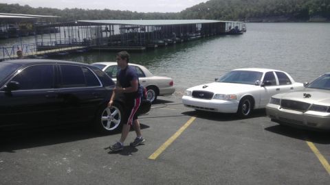 2000 Mercury Grand Marquis - Multiple sedans are parked near a body of water with docks in the background.