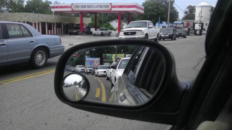 2000 Mercury Grand Marquis - Traffic moves past a gas station, with several cars visible in the side mirror.