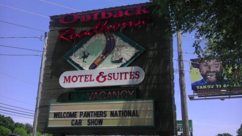 2000 Mercury Grand Marquis - A sign advertises the Outback Roadhouse Motel & Suites and an upcoming car show.