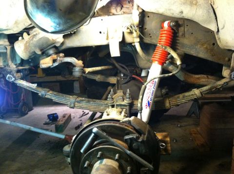 1983 Chevrolet C/K Pickup - Close-up view of a truck's front suspension system, showing leaf springs and a shock absorber.