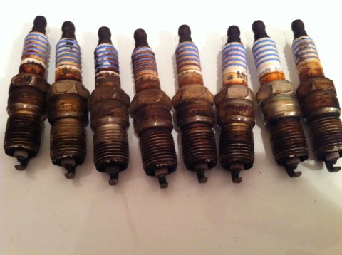 2001 Mercury Grand Marquis - Set of eight used spark plugs, some showing signs of wear and fouling.