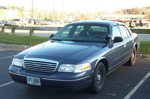 1991 Ford LTD Crown Victoria - This dark blue Ford Crown Victoria is parked in a lot, showing its front 3/4 view with a visible license plate.