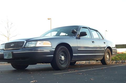 1991 Ford LTD Crown Victoria - This dark blue sedan, likely a late 1990s model, is seen from a 3/4 front angle. The license plate is visible and reads 145 3445.