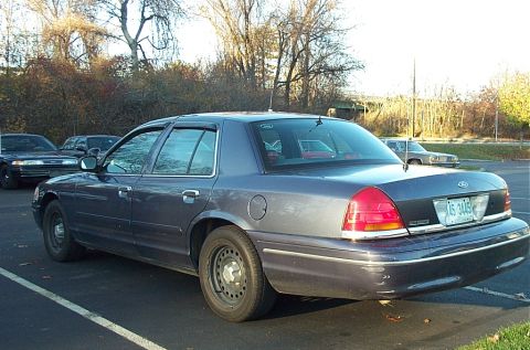 1991 Ford LTD Crown Victoria - A dark blue Ford Crown Victoria is parked in a lot with other vehicles visible in the background.