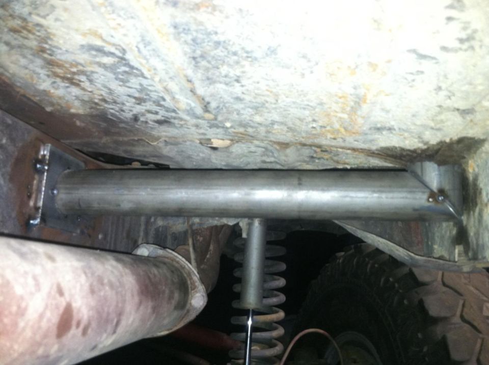 Underbody view of roll cage tubing and exhaust pipe, with a tire visible