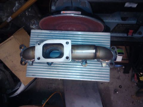 1995 Ford Probe - An exhaust manifold with a square flange is shown, likely a car part.