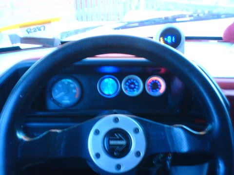 1989 Ford Bronco - Aftermarket gauges illuminate the dashboard, centered around a MOMO steering wheel.