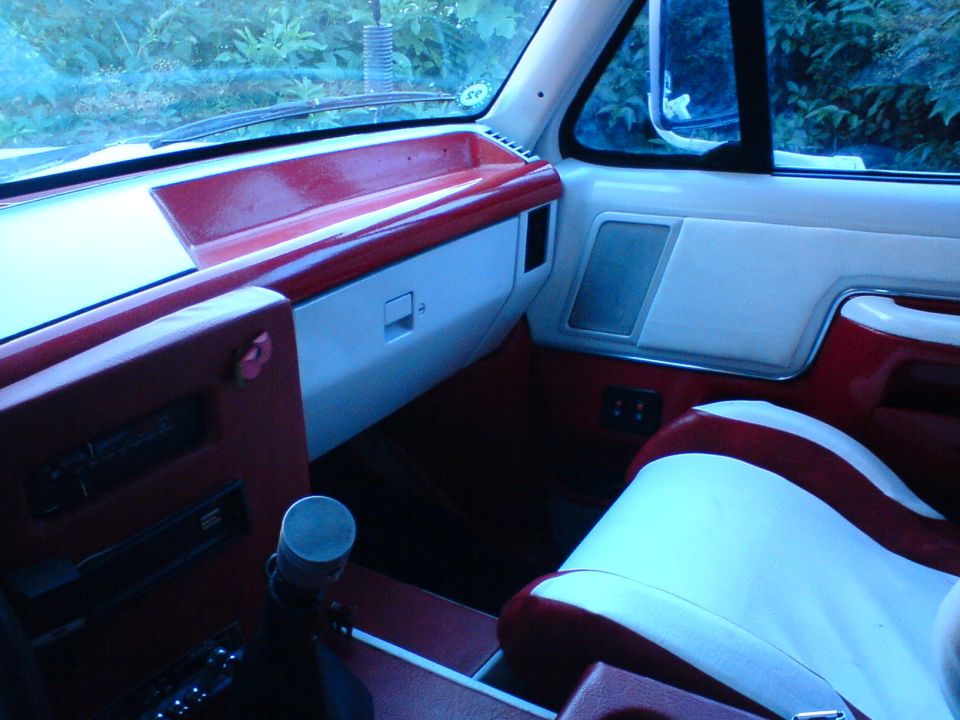 Interior view of a vehicle with red and white two-tone seats and dashboard