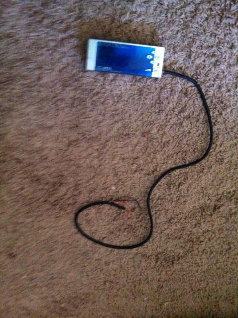 1991 Eagle Talon - A portable media player with a blue screen and a black cord lies on a textured carpet.