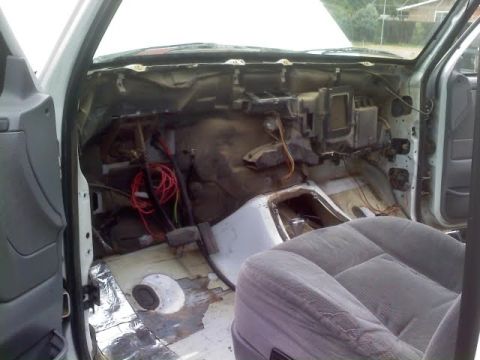 1996 Ford Bronco - The interior of the vehicle is partially disassembled, revealing the dashboard's internal components and wiring.