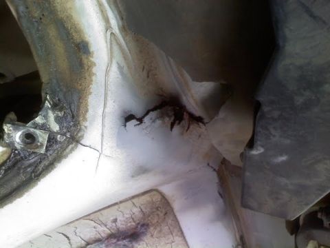 1996 Ford Bronco - Close-up of damaged and rusted metal frame, showing cracks and wear.