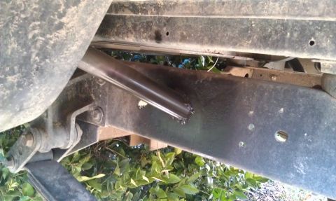 1978 Ford Bronco - The underside of a vehicle shows its frame, suspension, and a newly welded metal tube.