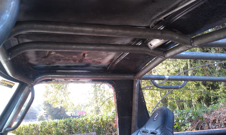 Interior view of a roll cage with a black seat and a Supermotors.net watermark