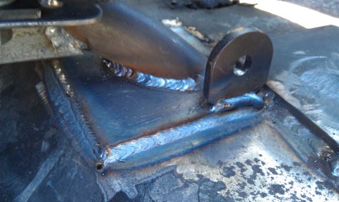 1978 Ford Bronco - Welded metal bracket with a circular mounting hole.