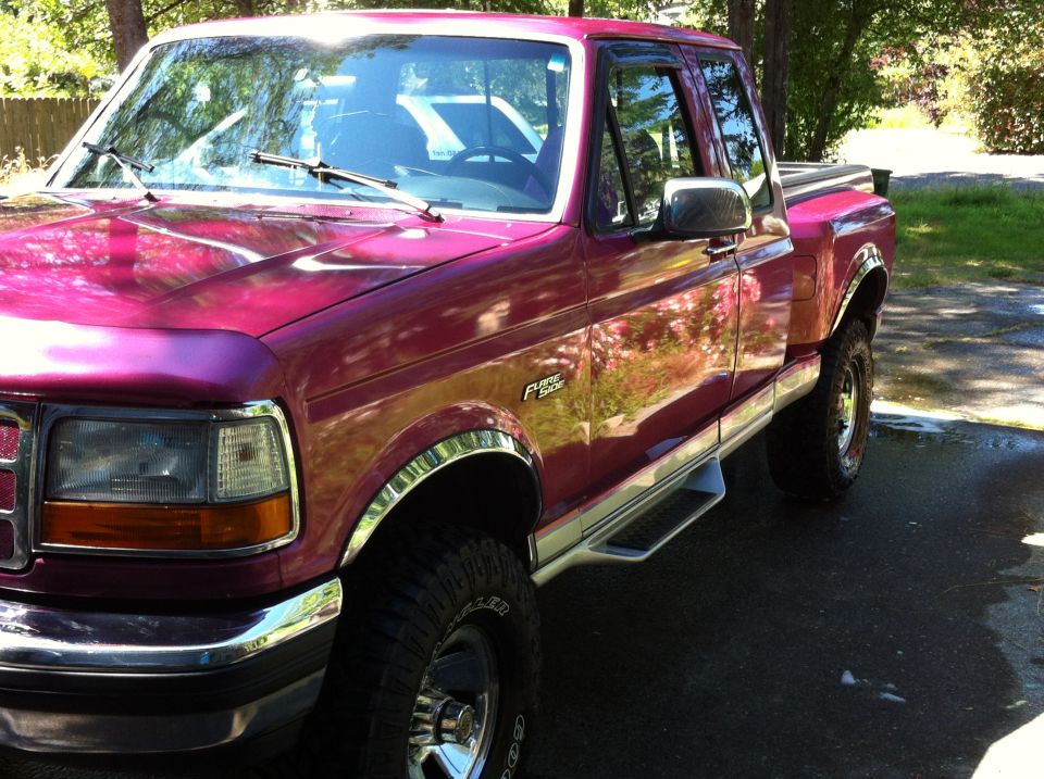 Purple Ford F-250 extended cab pickup truck, front quarter view. Chrome trim and running boards visible