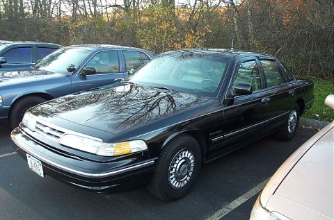 1991 Ford LTD Crown Victoria - A black 1991 Ford Crown Victoria LTD is parked in a lot, with other vehicles visible.