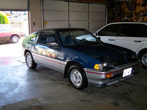 1988 Suzuki Samurai - This Honda CRX is parked in a garage with another vehicle. The hood is open.