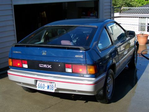 1988 Suzuki Samurai - A blue Honda Civic CRX is parked in front of a garage, showing its rear end and Washington state license plate.