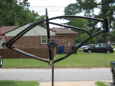 1994 Ford Bronco - A black bicycle frame is mounted on a stand, with a residential scene visible behind it.