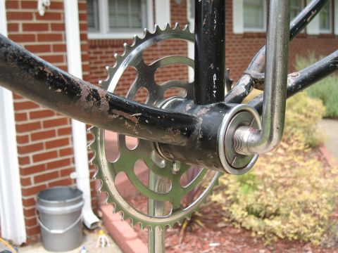 1994 Ford Bronco - The image shows a close-up view of a bicycle's crankset and chainring, with a brick house in the background.