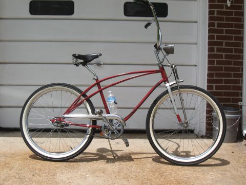 1994 Ford Bronco - A red cruiser bicycle with whitewall tires is parked in front of a garage door.