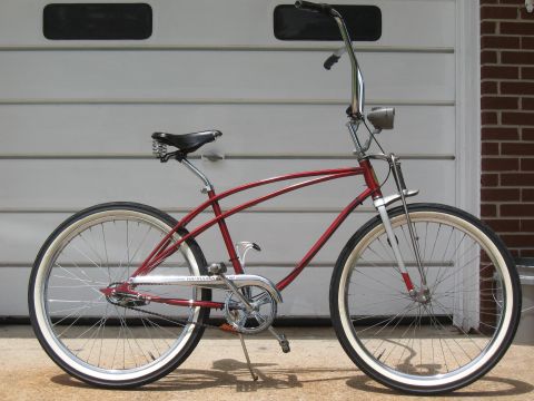 1994 Ford Bronco - A red cruiser bicycle with chrome accents and whitewall tires is shown from the side in front of a garage.