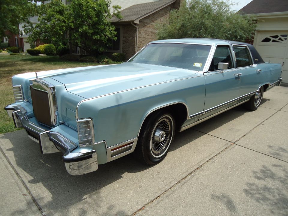 Light blue 1970s Lincoln Continental sedan parked in a suburban driveway
