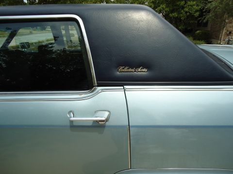 2001 Ford Crown Victoria - A light blue car features a black vinyl top with a 'Collector's Series' emblem on the rear quarter panel.