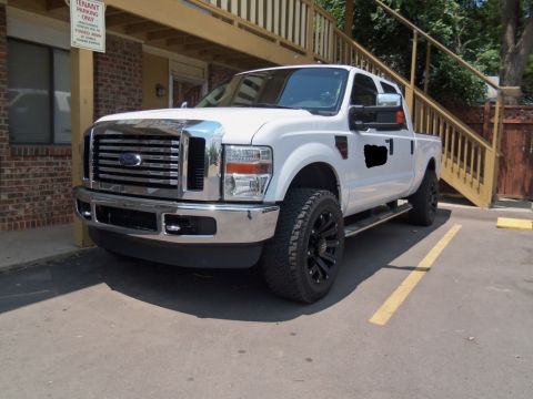 2000 Mercury Grand Marquis - A white Ford F-Series pickup truck is parked in a parking spot next to a building with an outdoor staircase.