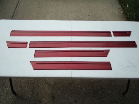 2001 Ford Crown Victoria - Red trim pieces are displayed on a white surface, possibly for sale or repair.