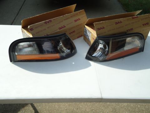 2001 Ford Crown Victoria - Two new headlight assemblies are displayed on a table, ready for installation.