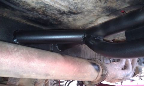 1978 Ford Bronco - Close-up view of a custom roll cage and exhaust system installed on the underbody of a vehicle.