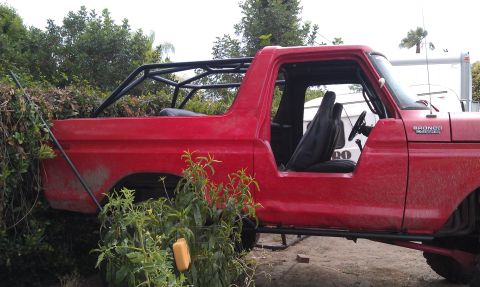 1978 Ford Bronco - This red Ford Bronco has a custom roll cage installed and is missing its doors and top.