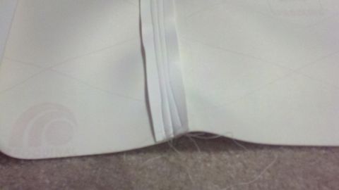 1900 Ford C-350 (Centurion Conversions) - Detail of a stitched seam on white upholstery, likely from a vehicle interior.