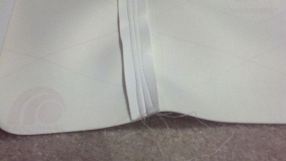 Close-up of a white interior upholstery seam with stitching