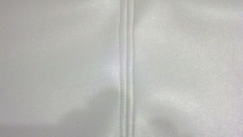 1900 Ford C-350 (Centurion Conversions) - A close-up view of white upholstery shows a prominent vertical seam with double stitching.