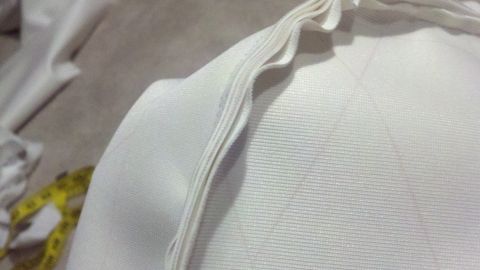 1900 Ford C-350 (Centurion Conversions) - A close-up view of white fabric with a measuring tape and a website logo.