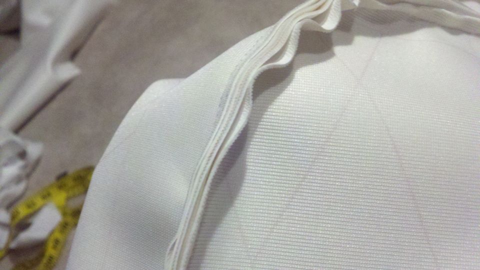 White fabric with a yellow measuring tape on the left. Supermotors.net logo in the bottom right