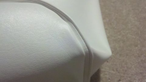 1900 Ford C-350 (Centurion Conversions) - A close-up view of white upholstery, possibly from a boat's interior, with visible stitching.