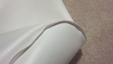 1900 Ford C-350 (Centurion Conversions) - Close-up view of white upholstery with a subtle curve, showing texture and stitching detail.