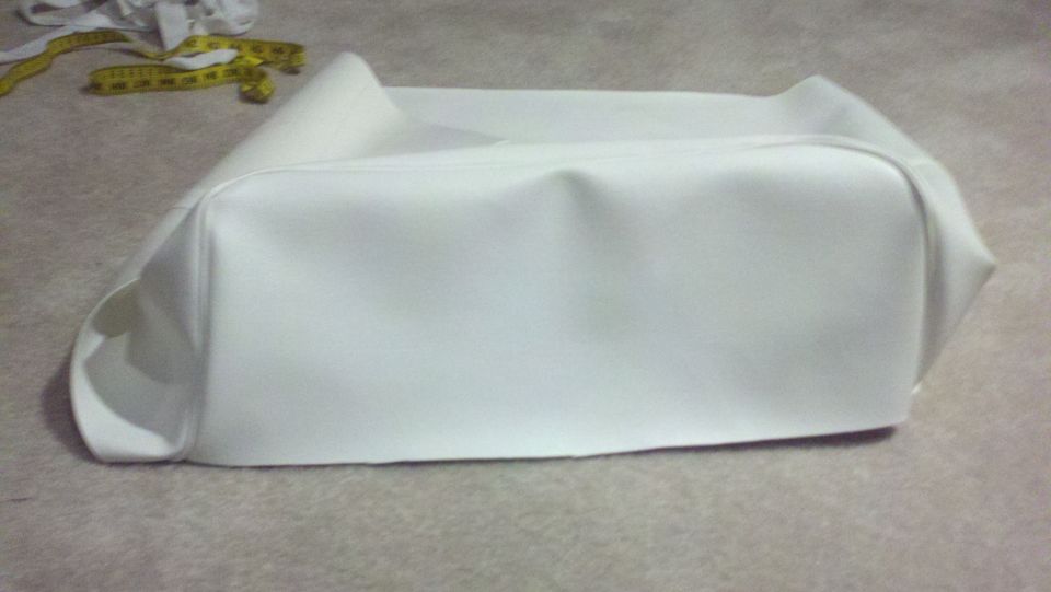White vinyl seat cover with yellow measuring tape and fabric scraps