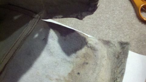 1900 Ford C-350 (Centurion Conversions) - A close-up view of stained fabric with visible stitching, alongside a pair of orange-handled scissors.
