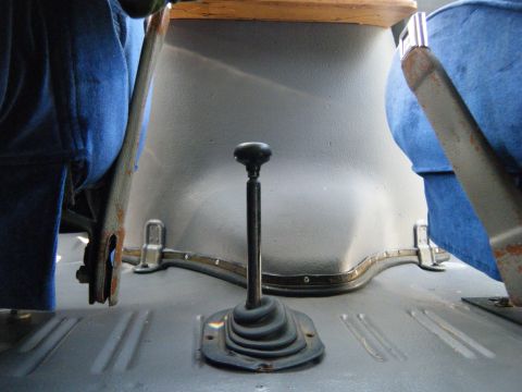1988 Ford E350 - The interior of a vehicle features a gear shifter and blue upholstered seats.