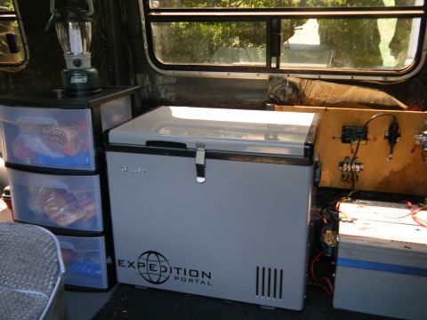 1988 Ford E350 - Interior of a van equipped with a portable refrigerator, storage drawers, and electrical components.